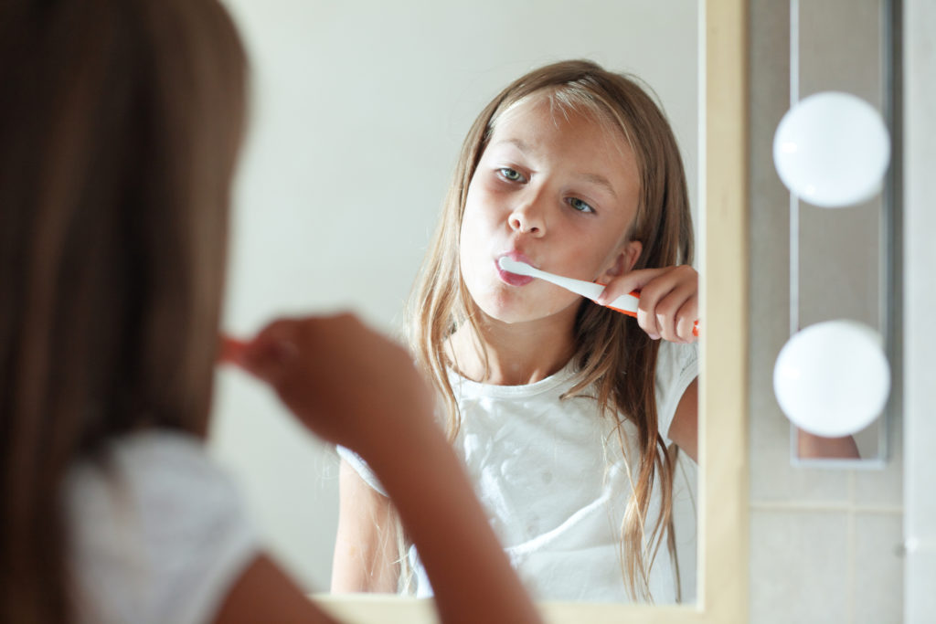 Little girl brushes teeth in the bathroom
